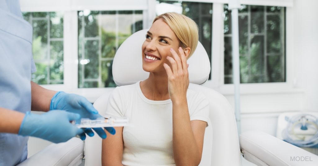 Beautiful young woman at medical clinic looking at her surgeon (model)