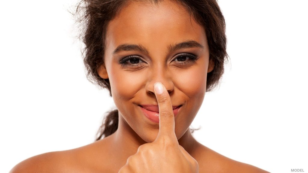 Woman looking forward touching nose (model)