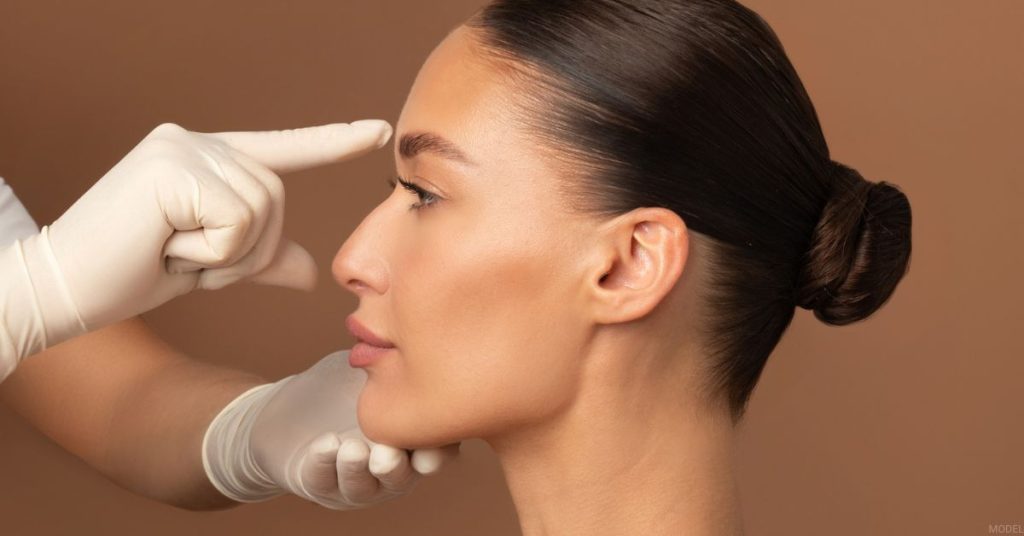 Woman receiving a rhinoplasty consultation (model)