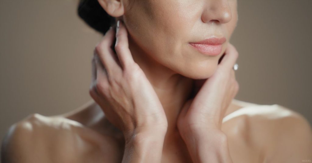 Woman touching her neck (model)